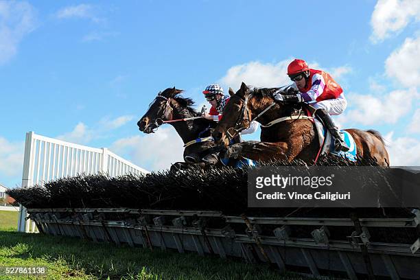 John Allen riding Waxing jumps the last hurdle along side Shane Jackson riding Saddle The Stars before winning Race 1,the Decron Maiden Hurdle during...