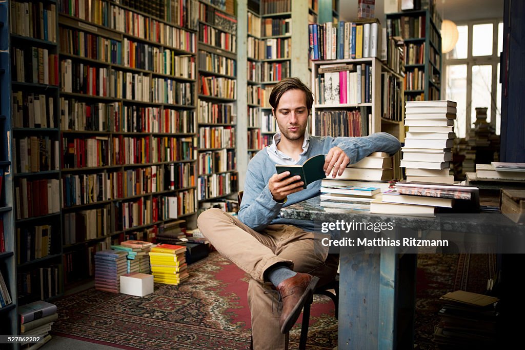 Man reading books in bookstore