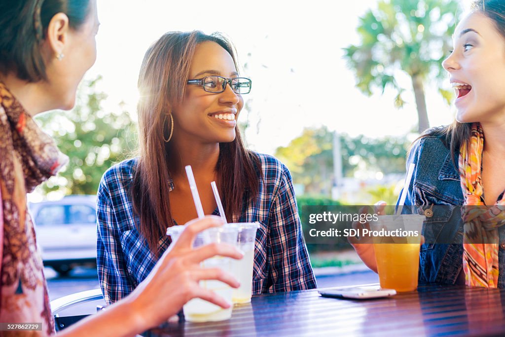 Young adult women enjoying drinks together on patio