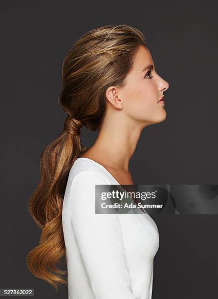 profile of woman with long hair - ponytail hairstyle stock pictures, royalty-free photos & images