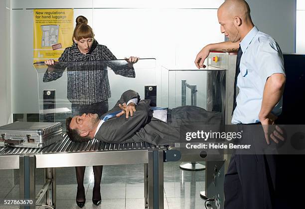 businessman going through the airport x-ray machine - airport x ray images stock-fotos und bilder