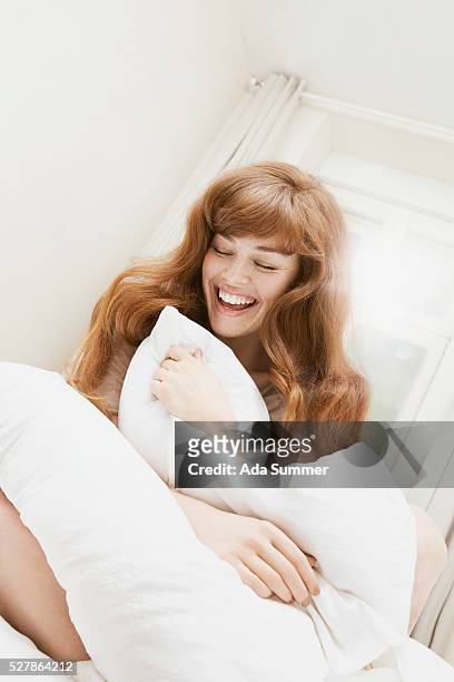 young woman smiling - women touching herself in bed stock pictures, royalty-free photos & images