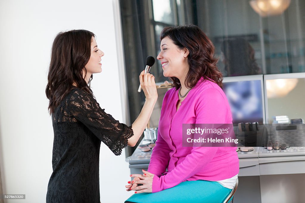 Make-up artist applying make-up to customer in salon