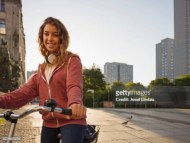 portrait of teenage girl (16-17) on bike in city - alleen tieners stockfoto's en -beelden