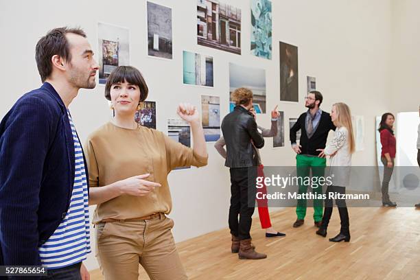 people watching exhibition of photos - exibition fotografías e imágenes de stock