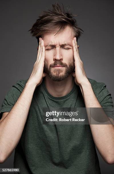 bearded man having a headache - headache imagens e fotografias de stock