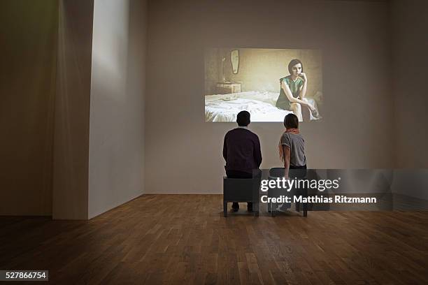 couple watching movie projected on wall - couple art gallery stock pictures, royalty-free photos & images