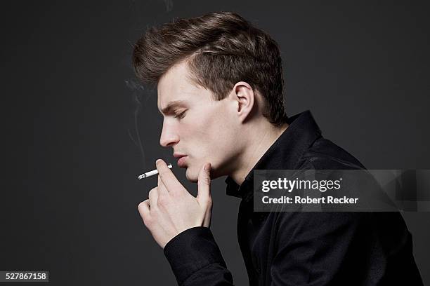 handsome young man smoking - タバコを吸う ストックフォトと画像