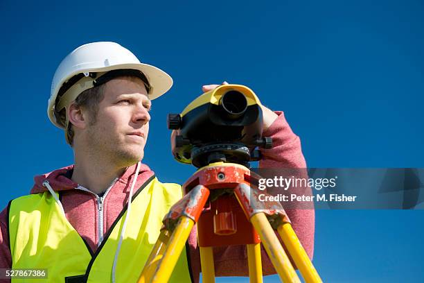 male surveyor using theodolite - géomètre photos et images de collection