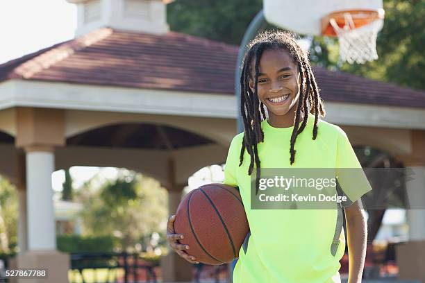 portrait of teenage boy (13-15) with basketball - alleen tienerjongens stockfoto's en -beelden