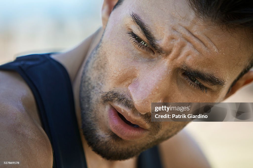Young man exercising, sweating