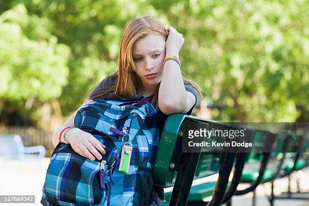 depressed school girl (10-12) sitting on bench - alleen één meisje stockfoto's en -beelden