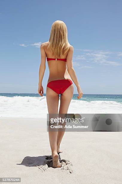 back view of young woman wearing red bikini, cape town, south africa - red swimwear stock pictures, royalty-free photos & images