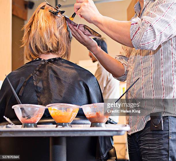 woman having hair colored in salon - haarkleuring stockfoto's en -beelden