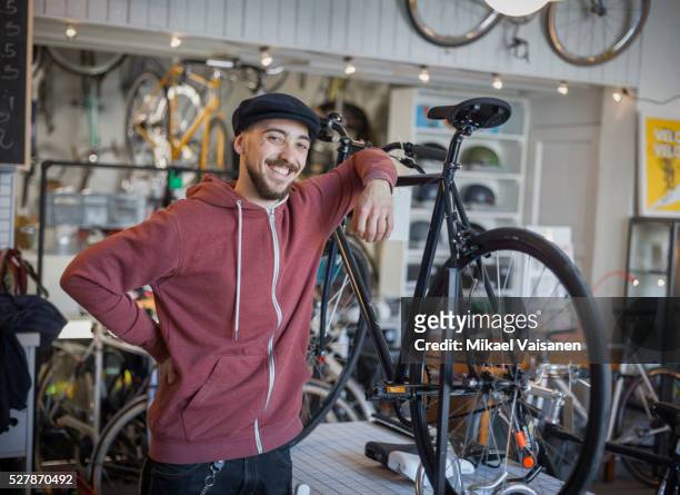young man in bicycle shop - shop seller stock-fotos und bilder