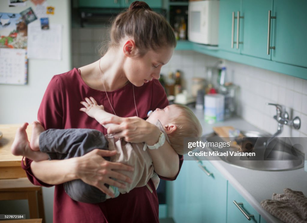 Mother embracing son (2-3) in kitchen