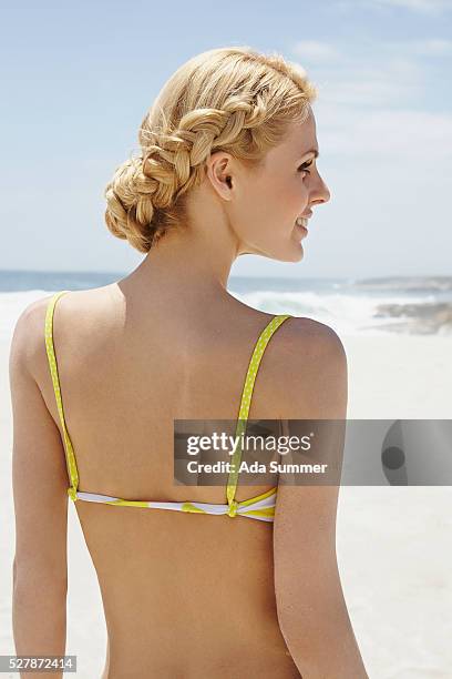woman with braided hair in bikini on beach - frau zopf hinten stock-fotos und bilder