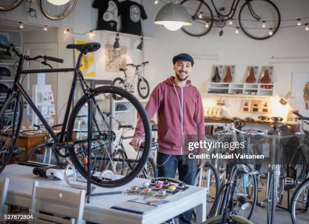 young man in bicycle shop - entrepreneurs fotografías e imágenes de stock