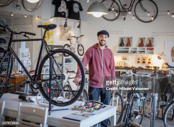 young man in bicycle shop - entrepreneur stock pictures, royalty-free photos & images