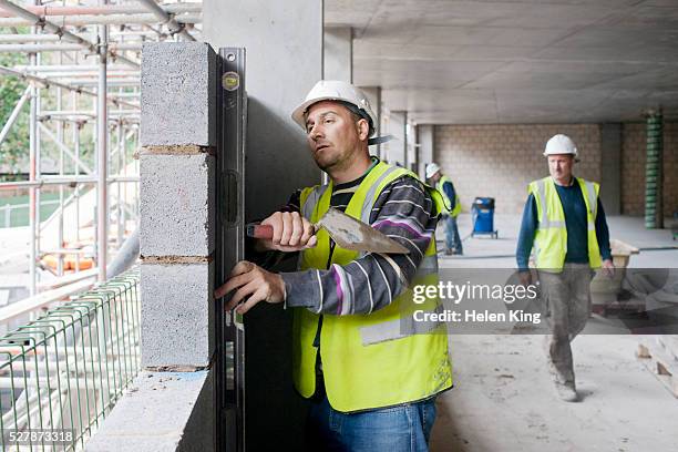 bricklayer using spirit level to check brick laying - brick layer bildbanksfoton och bilder