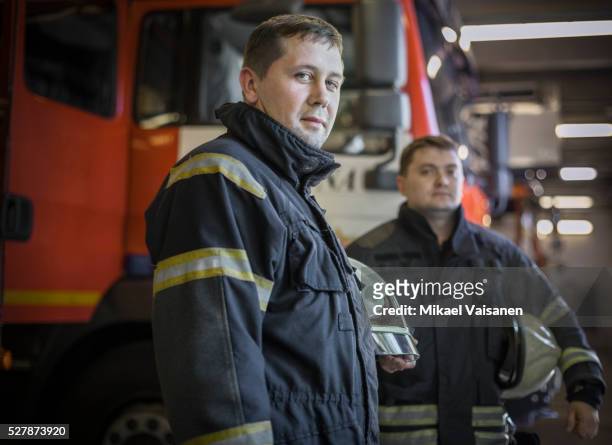 firefighters at fire station - fireman stock-fotos und bilder