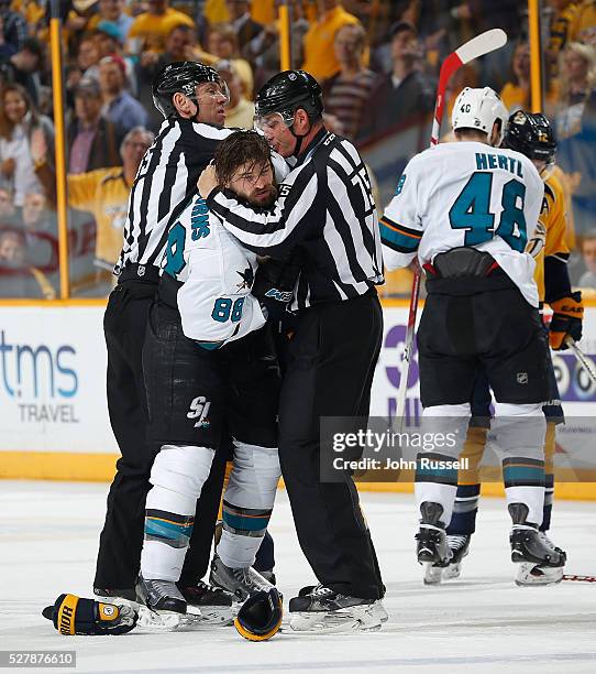 Linesmen Pierre Racicot and Derek Amell separate Brent Burns of the San Jose Sharks and Barret Jackman of the Nashville Predators in Game Three of...