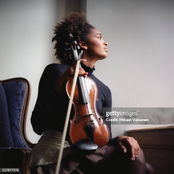 young woman holding violin - violin fotografías e imágenes de stock