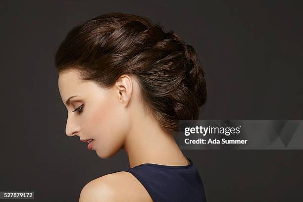 portrait of young woman with braided hairbun, studio shot - braided buns stock pictures, royalty-free photos & images