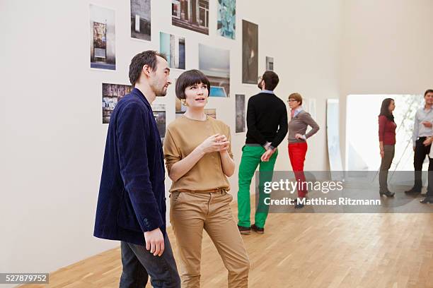 people watching exhibition of photos - museum stockfoto's en -beelden