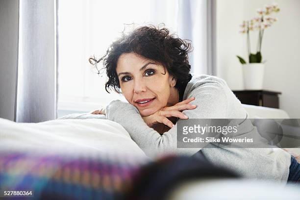 portrait of relaxed woman in living room - 50 59 years stock pictures, royalty-free photos & images