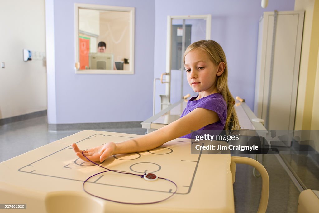 Girl (7-9) having anterior-posterior of her forearm using digital diagnose general radiography machine