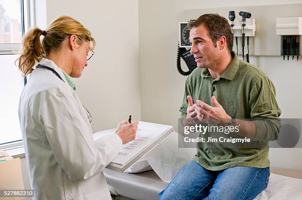 patient talking to doctor - 40 49 years stock pictures, royalty-free photos & images