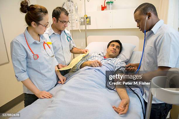 three doctors examine a hospital patient - archival hospital stock pictures, royalty-free photos & images