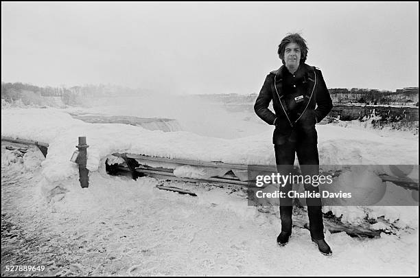 English singer-songwriter Nick Lowe poses at a frozen Niagara Falls in minus 40 degree temperatures, New York, March 1978.