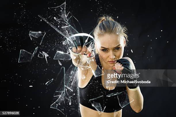 women fighter punching close up glass shattering - punching stock pictures, royalty-free photos & images