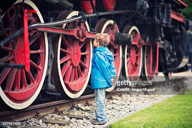 little boy y la locomotora de vapor. - locomotive fotografías e imágenes de stock