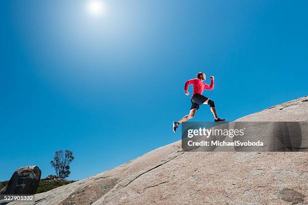 männliche laufen einen granit-boulder in den bergen - uphill stock-fotos und bilder