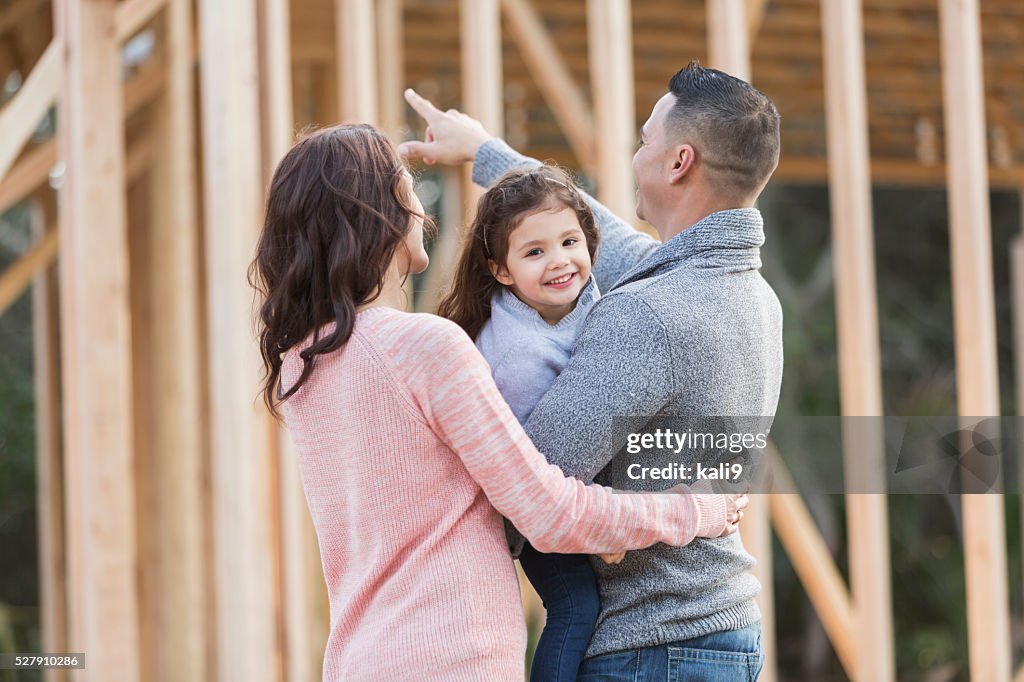 Hispanic family building a new home, happy girl