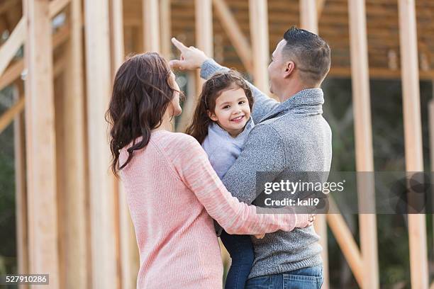hispânico família construir uma nova casa, rapariga feliz - couple pointing imagens e fotografias de stock
