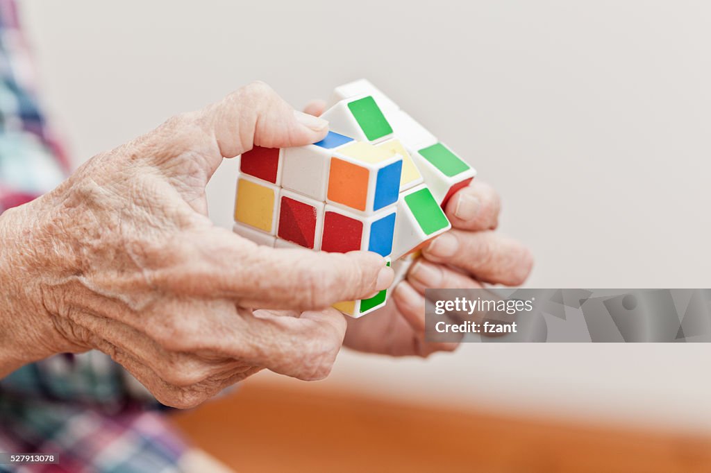 Senior woman playing a cube game