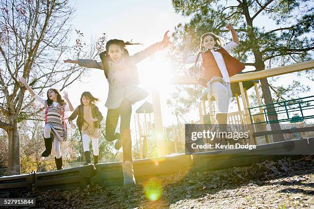girls (6-9) in playground with lens flare - schoolplein stockfoto's en -beelden