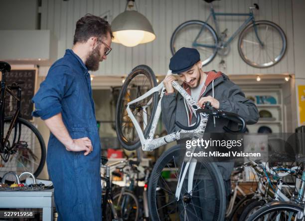 customer with mechanic looking at ultra light bicycle in bike shop - buying a bike bildbanksfoton och bilder