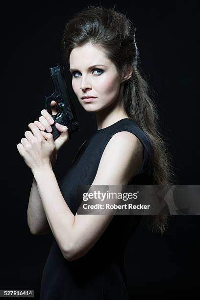 young woman holding handgun - handgun foto e immagini stock