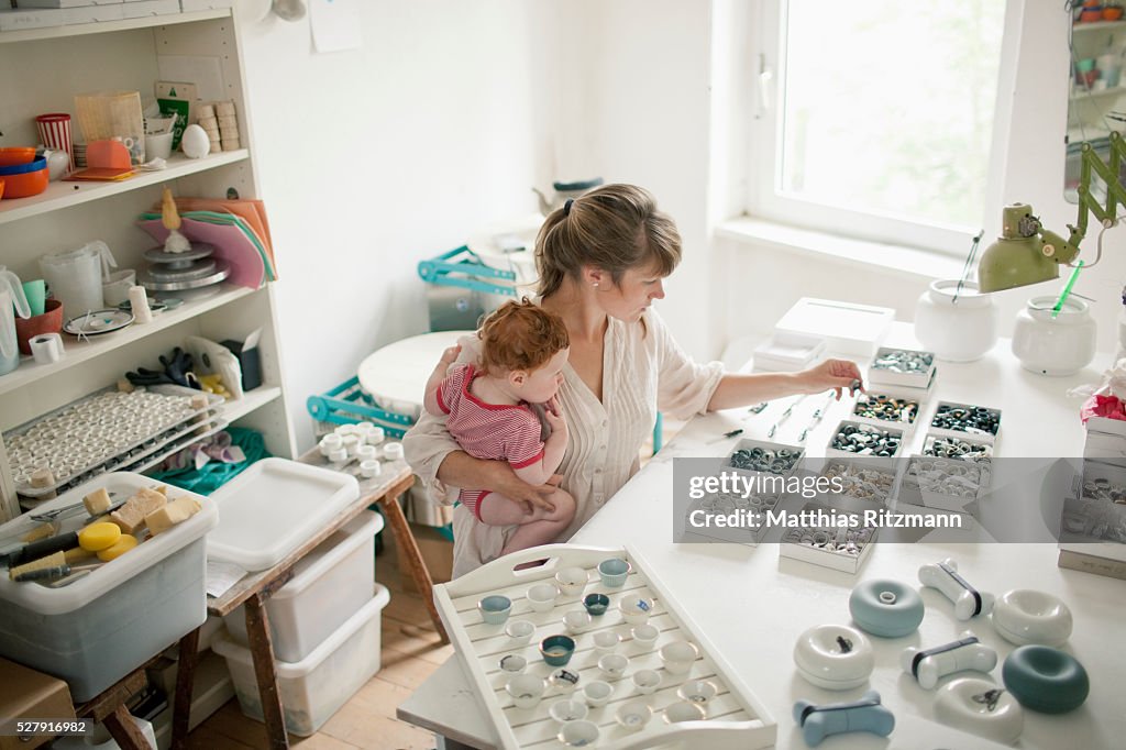 Young mother working with child (6-12 months) on her lap