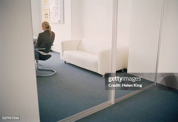 businesswoman at desk - sliding door photos et images de collection