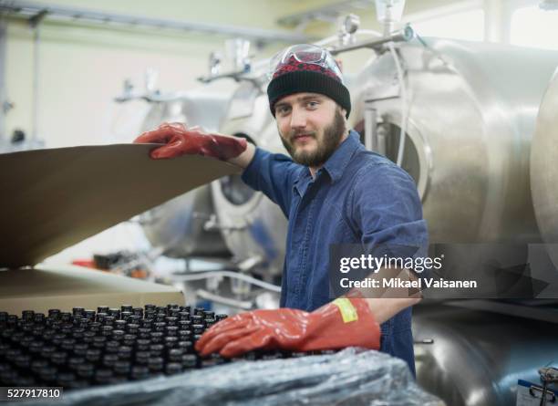 worker in blue overall in microbrewery - brauerei stock-fotos und bilder