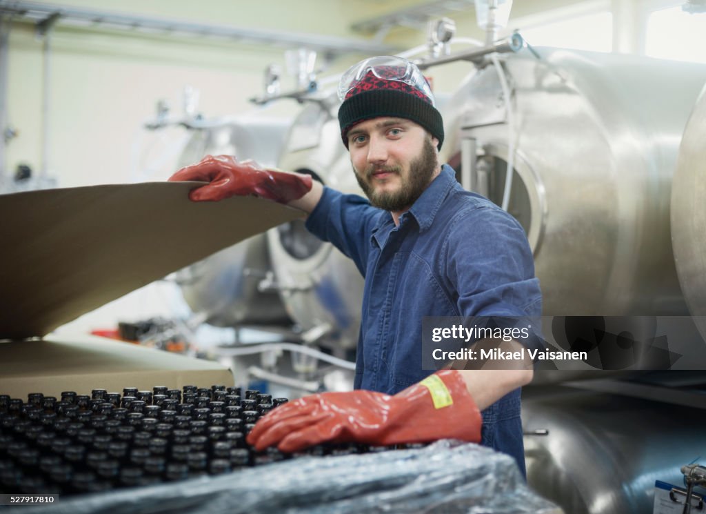 Worker in blue overall in microbrewery