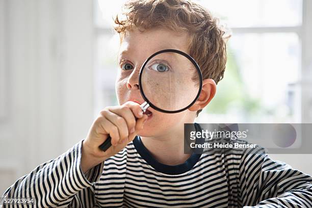 boy (7-9) with magnifying glass - child magnifying glass stock-fotos und bilder