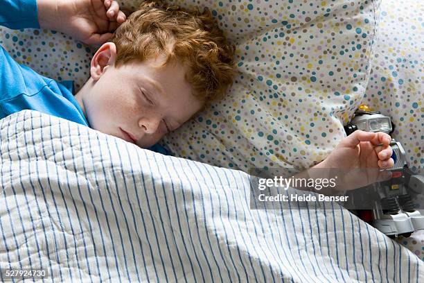 boy (7-9) sleeping - boy asleep in bed stock-fotos und bilder