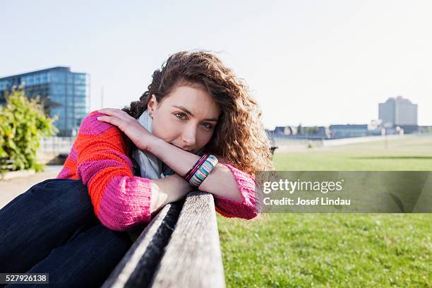 confident woman sitting on a bench - josef lindau stock-fotos und bilder